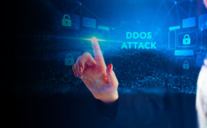 Illustration of a gamer sitting at a desk with a computer, wearing headphones, and holding a game controller. The background features a digital representation of a DDoS attack with various icons and symbols indicating network disruption and cybersecurity threats.
