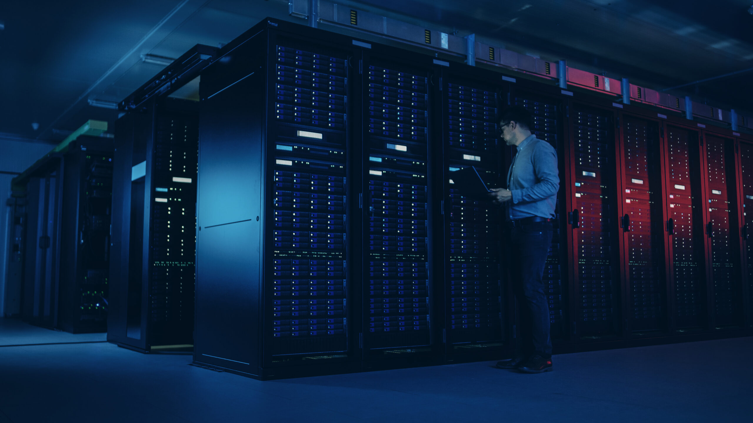 A modern data center with rows of server racks illuminated by blue and purple lights, showcasing advanced technology infrastructure.