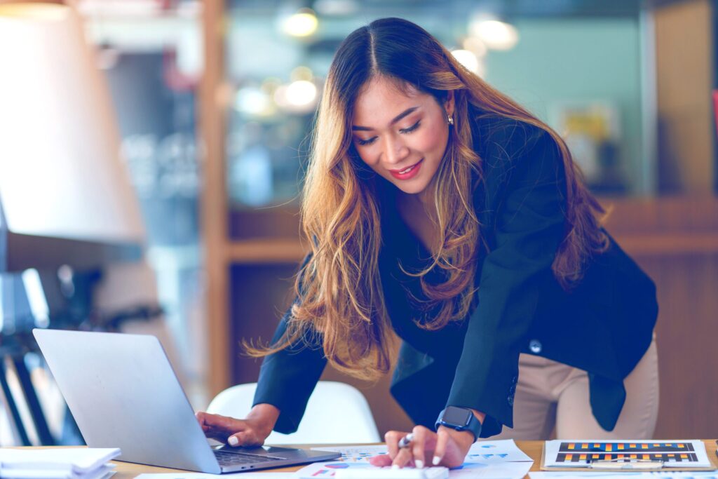 Business professional analyzing data and reports on laptop